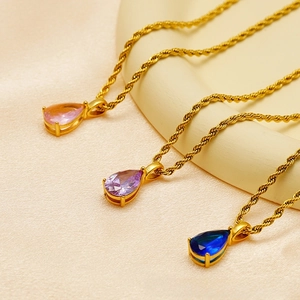 Detail of waterdrop pendants on gold rope chains in pink, purple and dark blue shades
