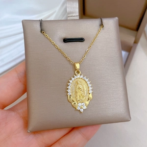 Macro detail of gold lotus portrait necklace with pavé diamonds on a display pad
