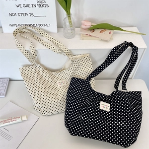 Detailed view of large polka dot canvas tote bags in black and white styles