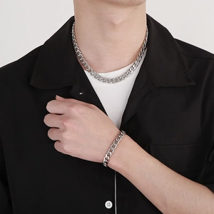 Polished silver stainless steel Cuban link necklace and bracelet set worn by male model