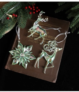 Close-up of iridescent acrylic reindeer and snowflake ornaments on a vintage book