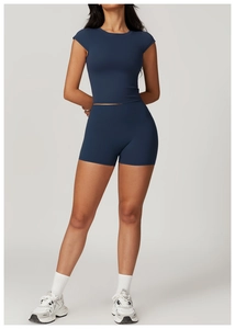 Detail showing navy blue short sleeve crop top and high waist sports shorts on a model
