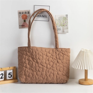 Close-up of brown quilted tote bag with unique 3D flower pattern stitching texture