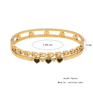 Vue détaillée d'un bracelet jonc double couche en acier doré avec cœurs noirs et cristaux