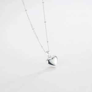 Macro shot of 925 sterling silver heart pendant necklace with delicate beaded chain