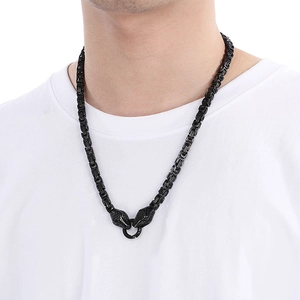 Detailed view of black Byzantine chain necklace featuring dual snake head design on model