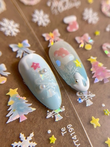 Detail of Christmas nail stickers with snowflake patterns and pearls on light blue tips