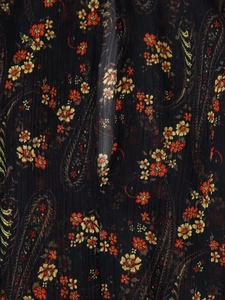 Close-up of black chiffon fabric with vibrant floral paisley print and pleated texture