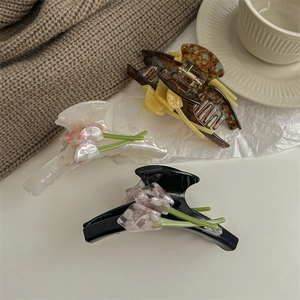 Three elegant tulip flower hair claws in black, white, and tortoiseshell acetate