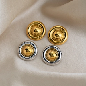 Boucles d'oreilles disques polis en or 18 carats et argent sur un tissu en soie