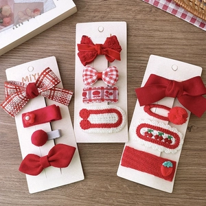 Detailed set of red bow and strawberry fabric hair clips for girls on display cards