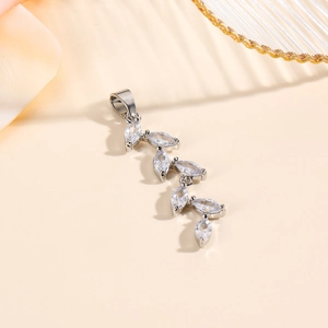 Silver leaf pendant with marquise-cut zircon stones on an elegant warm background