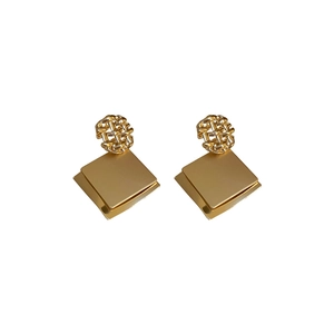 Golden geometric earrings with woven knots and tiered square metal sequins on white background