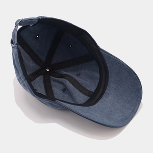 Detail view of denim baseball cap interior featuring black sweatband and reinforced stitching