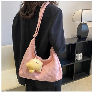 Pink checkered plush shoulder bag with yellow star charm shown worn by a model