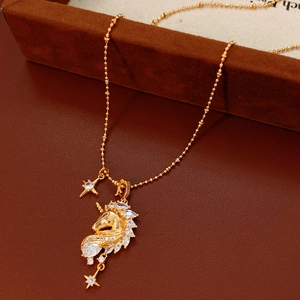Macro shot of gold-plated unicorn pendant with sparkling zircons and fine star charms