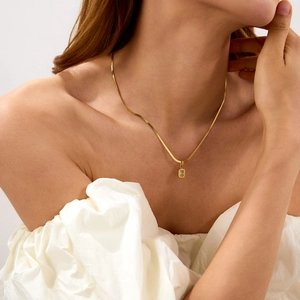 Dettaglio di una collana placcata in oro 18k con pendente rettangolare in zircone su modella