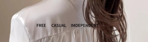 Detail of the white satin long sleeve blouse showing the elegant back pleat design