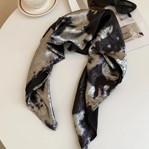 Détail du foulard Y2K argent liquide avec texture léopard sur une table en marbre