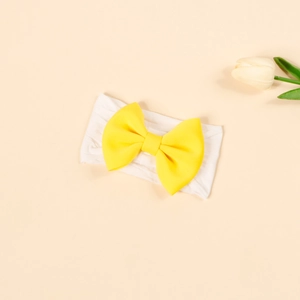 Elastic baby headband with bright yellow bow and white wide nylon band shown from above