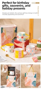 Close-up of ceramic mug with unique heart-shaped handle, gold spoon and elegant gift box