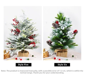 Detailed view of snowy Christmas trees with red berries and burlap wrapped bases