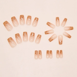 Macro shot of gradient brown press-on nails with luxury gold foil and cat-eye leopard pattern
