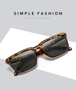 Detail of tortoise shell rectangular sunglasses with dark lenses on a minimal background