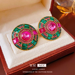 Orecchini vintage dorati con strass rosa e gemme verdi in una scatola di lusso