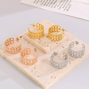 Detailed macro view of hollow chain earrings in gold, rose gold, and silver finishes
