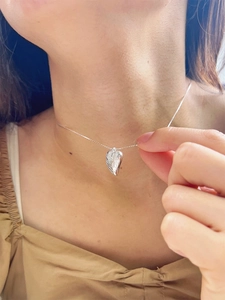 Elegance of a silver 925 heart shell pendant necklace worn on a woman's collarbone