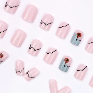 Minimalist pink press-on nails with black wavy lines and blue abstract eye art