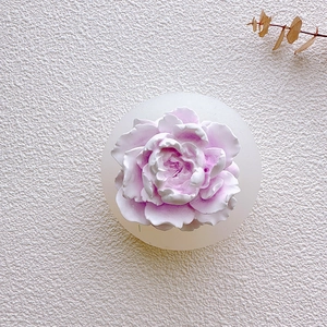 Top view of handmade jasmine flower candle showing detailed white and pink petals