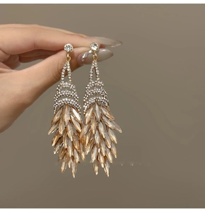 Detailed view of layered champagne gold tassel earrings with marquise cut crystals