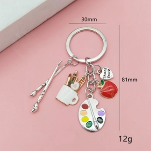Close-up of artist palette keychain with paintbrushes and Thank You heart charm