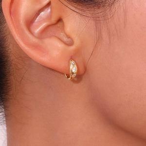 Detailed view of s925 gold huggie earrings with sparkling star-shaped zircon inlays