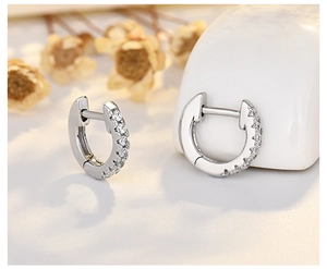 Macro shot of silver hoop earrings with inset white zircon stones and polished finish