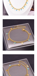 Detail of gold star and blue moon charms on titanium steel necklace and bracelet set