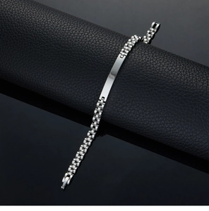 Detailed macro view of silver stainless steel chain bracelet on black leather display