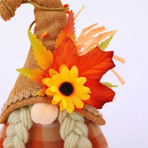 Close-up of harvest gnome with orange maple leaves, sunflower detail and burlap hat texture