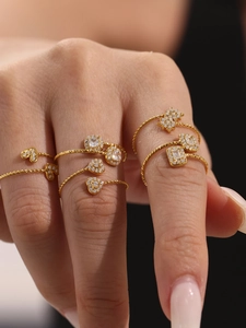 Détails macro de bagues torsadées plaquées or avec zircons en cœur et carrés élégants
