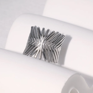 Macro shot of silver geometric ray wide band ring displayed on white pillar stand