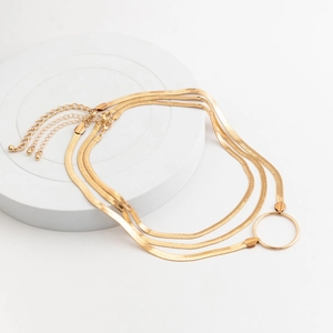Detailed view of triple layered gold snake chain necklace with central ring pendant