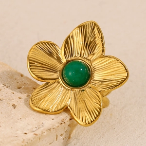 Vintage 18K gold plated flower ring with green turquoise stone on a warm rock base