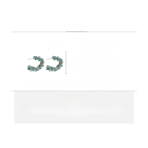 Detail view of C-shaped blue beaded earrings with silver pins and gold accents