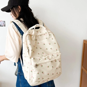 Detail view of cream-colored floral backpack with pink roses and adjustable straps