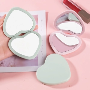 Portable heart-shaped folding double-sided makeup mirror in pastel pink and green