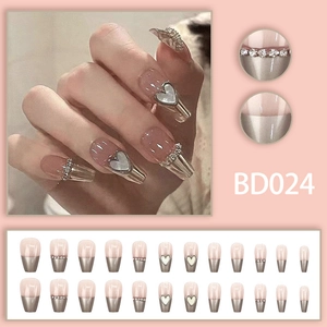 Detail of pink press-on nails with silver chrome tips, heart charms, and full set display