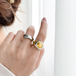 Close-up of dual-tone gold and silver stainless steel rings with a polished finish