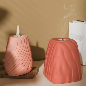 Artistic spiral and rock texture aromatherapy candles in minimalist matte clay vessels